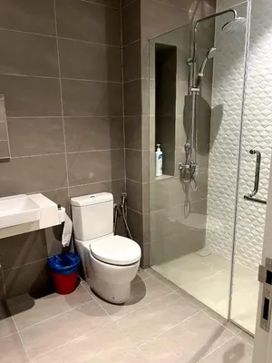 a bathroom with a shower and a toilet and a sink at Comfort Cove in Kuala Lumpur