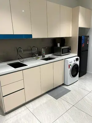 a kitchen with a washing machine and a microwave at Comfort Cove in Kuala Lumpur