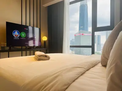 a hotel room with a bed with a flat screen tv at AXON RESiDENCE AT SERViCE APARTMENT in Kuala Lumpur
