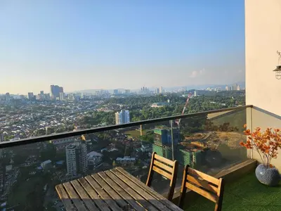 a balcony with a bench and a view of a city at The Establishment - Menara Teguh Bangsar in Kuala Lumpur