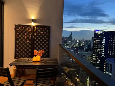 a table on a balcony with a view of a city at The Establishment - Menara Teguh Bangsar in Kuala Lumpur