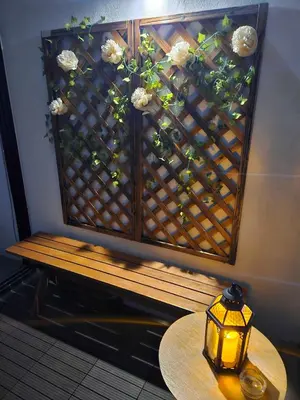 a bench with a table and flowers on a wall at The Establishment - Menara Teguh Bangsar in Kuala Lumpur