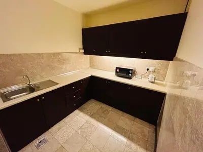 a kitchen with black cabinets and a sink at EVERYDAY SERVICE SUITE at TIMES SQUARE in Kuala Lumpur