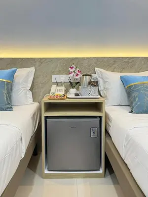 a room with two beds with a tv between them at AQ Hotel Bukit Bintang in Kuala Lumpur