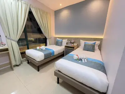 a bedroom with two beds and a window at AQ Hotel Bukit Bintang in Kuala Lumpur