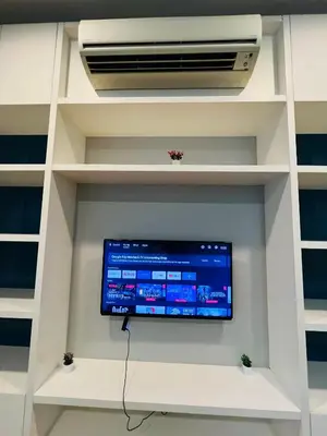 a tv in a white book shelf with a air conditioner at The Platinum KLCC by Dream Suites in Kuala Lumpur