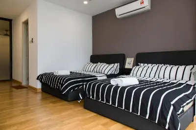 two beds in a room with black and white stripes at KL Gateway Bangsar by Sleepy Bear in Kuala Lumpur