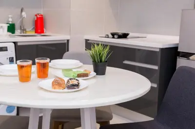 a white table with two plates of food and drinks at KL Gateway Bangsar by Sleepy Bear in Kuala Lumpur