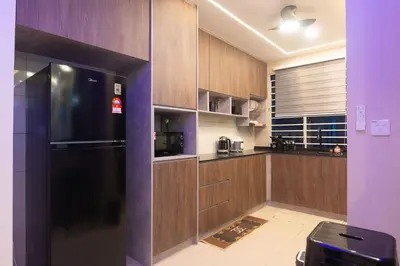 a kitchen with wooden cabinets and a black refrigerator at 3BR LSH33 KL Duke Highway Genting Free Parking in Kuala Lumpur
