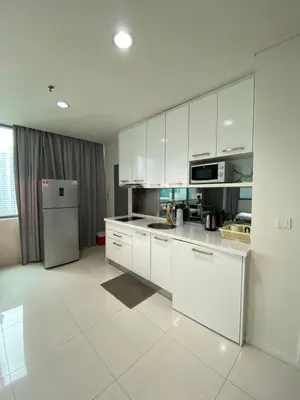 a kitchen with white cabinets and a refrigerator at Summer Suites KLCC by Angel in Kuala Lumpur