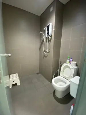 a bathroom with a toilet and a phone on the wall at Summer Suites KLCC by Angel in Kuala Lumpur