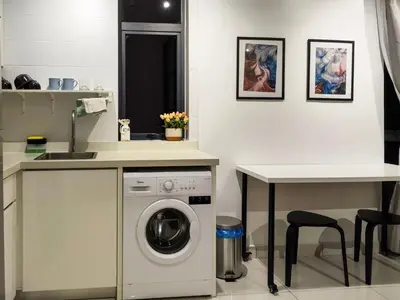 a kitchen with a washing machine and a table at Scenic Living Homestay Studio in Kuala Lumpur