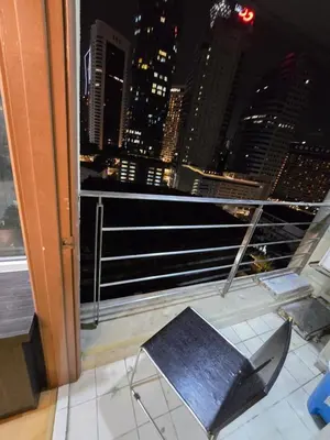 a chair in front of a window with a view of a city at Park view klcc by Alan in Kuala Lumpur