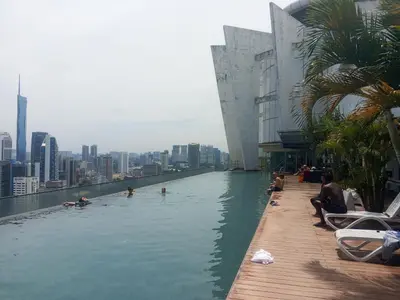 a infinity pool on the roof of a building with people swimming at Regalia Space Hostel in Kuala Lumpur