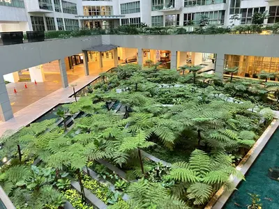 an indoor garden with green plants in a building at Regalia Space Hostel in Kuala Lumpur