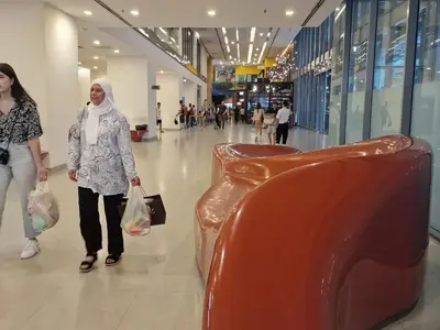 a woman walking through a shopping mall at Summer Luxury Suites KlCC by ATIQ in Kuala Lumpur