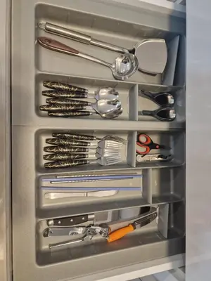 a refrigerator filled with lots of silver utensils at Summer Luxury Suites KlCC by ATIQ in Kuala Lumpur
