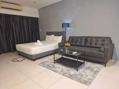 a living room with a couch and a bed at Summer Luxury Suites KlCC by ATIQ in Kuala Lumpur