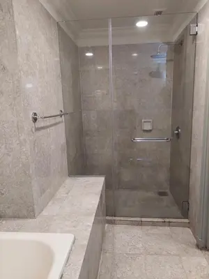 a bathroom with a shower with a sink and a glass shower door at Snowfall suite at berjaya Times Square in Kuala Lumpur
