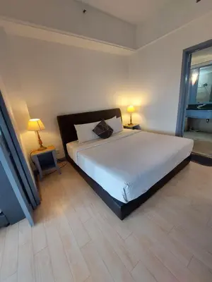 a bedroom with a large white bed with two lamps at Snowfall suite at berjaya Times Square in Kuala Lumpur