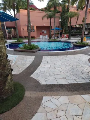 a courtyard with a swimming pool with palm trees at Snowfall suite at berjaya Times Square in Kuala Lumpur
