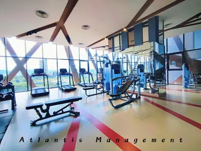a gym with several treadmills and machines and windows at Parc 3, Sunway Velocity in Kuala Lumpur