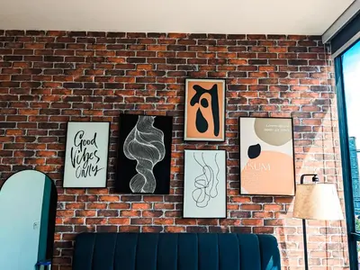 a brick wall with framed art on it at Scarletz Suites KLCC by IH in Kuala Lumpur