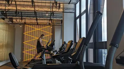 a woman in a gym with cardio equipment at Scarletz Suites KLCC by IH in Kuala Lumpur