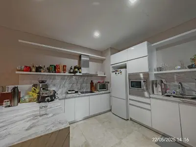 a kitchen with white cabinets and a white refrigerator at Icon Residence in Kuala Lumpur