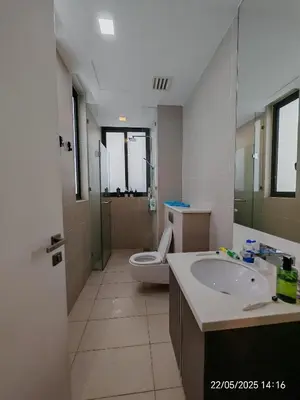 a bathroom with a toilet and a sink and a mirror at Icon Residence in Kuala Lumpur