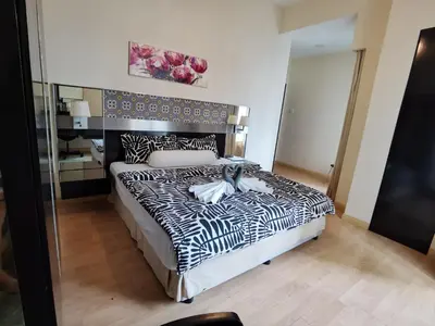 a bedroom with a black and white bed and a mirror at Seri Bukit Ceylon Bukit Bintang in Kuala Lumpur