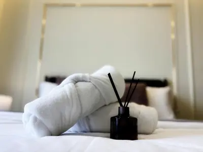 a person with their arm wrapped in towels on a bed at TRX Agile Bukit Bintang Deluxe 8 pax Family Suites in Kuala Lumpur