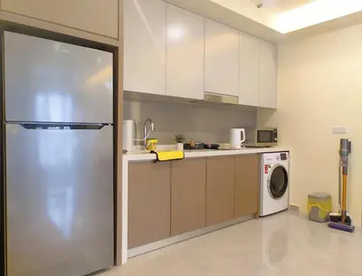 a kitchen with a refrigerator and a washing machine at TRX Agile Bukit Bintang Deluxe 8 pax Family Suites in Kuala Lumpur