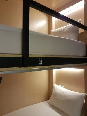 a couple of bunk beds with white pillows on them at Hotel 1000 Miles in Kuala Lumpur