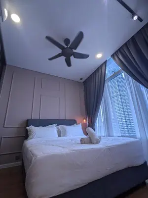 a bedroom with a ceiling fan and a bed with a window at Dawn Getaways in Kuala Lumpur