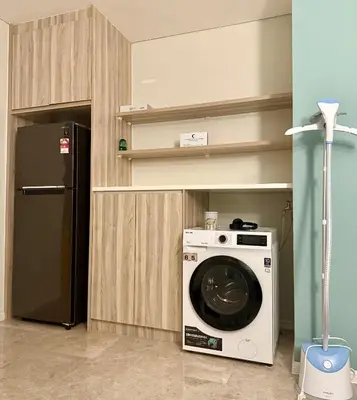 a kitchen with a washing machine and a refrigerator at Dawn Getaways in Kuala Lumpur
