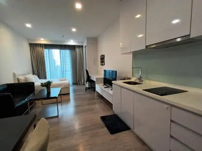 a kitchen and living room with a couch and a table at AK Residence in Kuala Lumpur