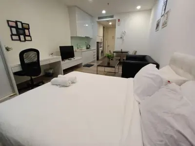 a bedroom with a white bed and a living room at AK Residence in Kuala Lumpur