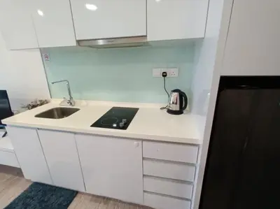 a white kitchen with a sink and a microwave at AK Residence in Kuala Lumpur