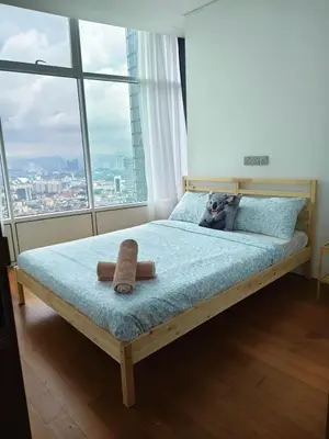 a dog laying on a bed in a room with a window at Sleep in the Sky KLCC View in Kuala Lumpur