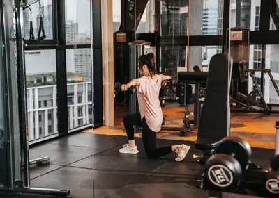 a woman doing squats in a gym at Scarletz Luxury Suites KLCC in Kuala Lumpur