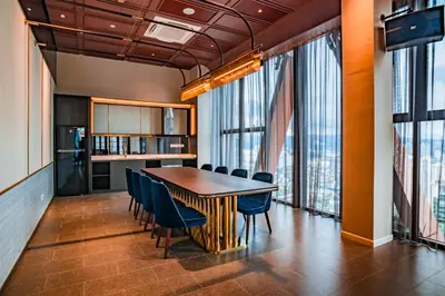 a dining room with a table and chairs and windows at Scarletz Luxury Suites KLCC in Kuala Lumpur