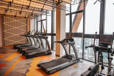 a row of exercise bikes in a gym with windows at Scarletz Luxury Suites KLCC in Kuala Lumpur