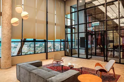 a lobby with a couch and chairs and large windows at Scarletz Luxury Suites KLCC in Kuala Lumpur