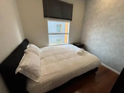 a bedroom with a white bed with a window at Sky Suites KLCC by Easy Nap in Kuala Lumpur
