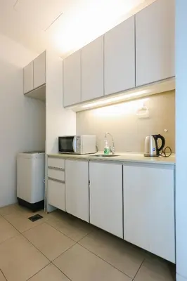 a kitchen with white cabinets and a sink at Swiss Garden Residence by Aspire Suites in Kuala Lumpur