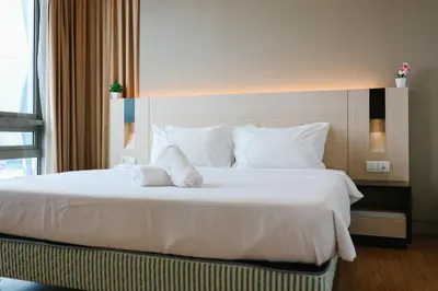 a bedroom with a large bed with white sheets and pillows at Swiss Garden Residence by Aspire Suites in Kuala Lumpur