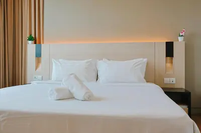 a large white bed with two towels on it at Swiss Garden Residence by Aspire Suites in Kuala Lumpur