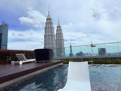 a pool on the roof of a building with tall buildings at Star Residence Sky World KLCC in Kuala Lumpur