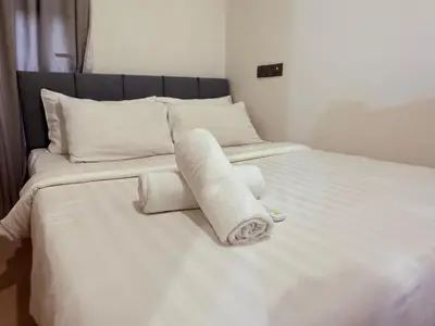 a white bed with towels and pillows on it at Star Residence Sky World KLCC in Kuala Lumpur